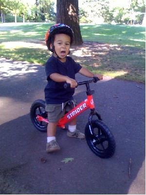 2 year old on red strider balance bike